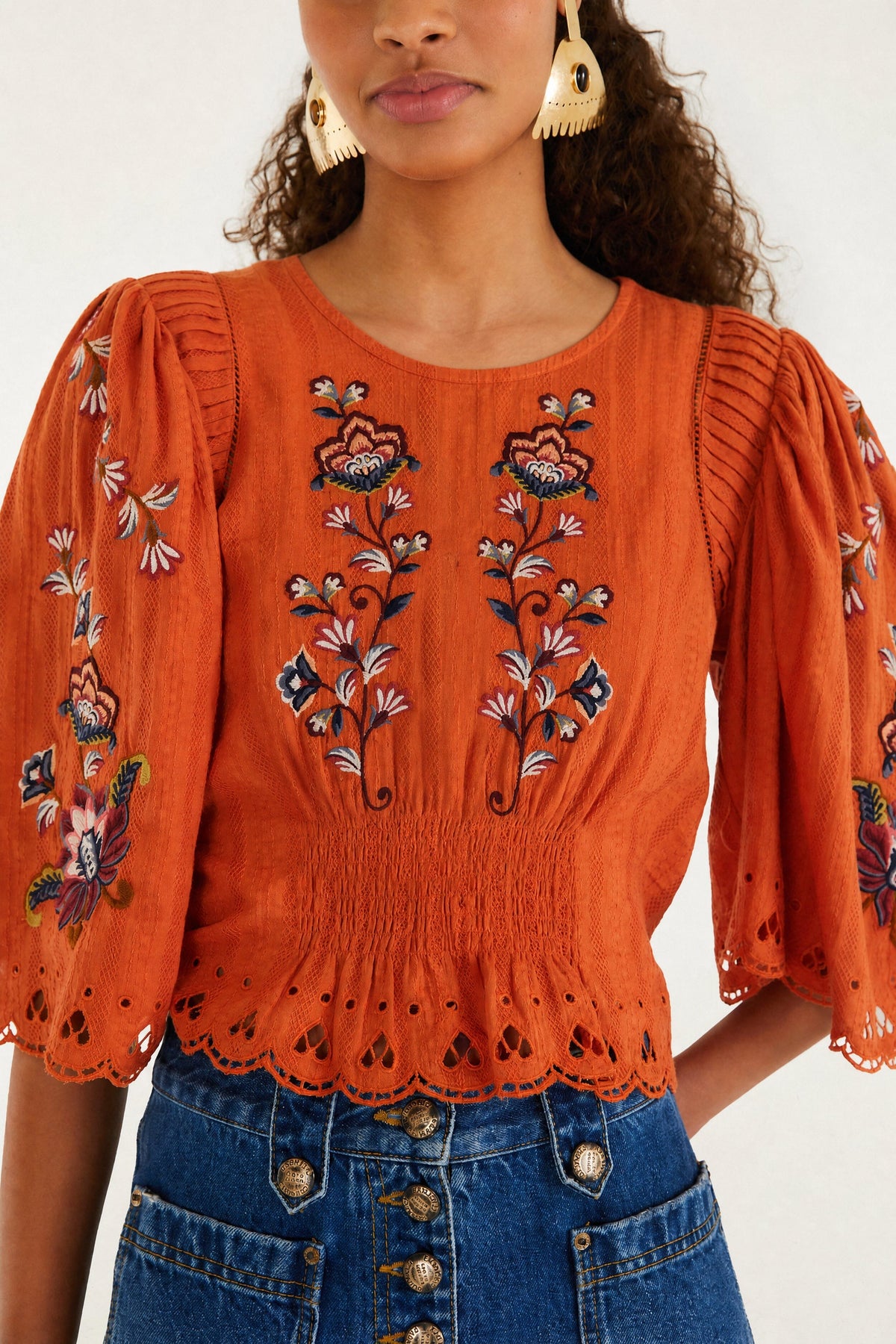 Blusa arancione con fiori boho ricamati e maniche a sbuffo